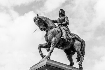 Equestrian statue of Joan of Arc (Jeanne d'Arc) in Orleans, France; bronze outdoor monument in black and white