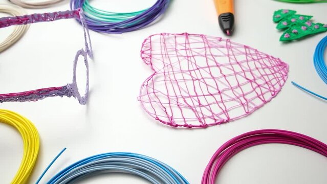 3d Pen. Printing with Colored Plastic Wire Filament. Child making a Christmas Three, Heart shape drawing with 3D pen. Artwork, Robotics. STEAM, STEM education. Modern Technologies. Study at home