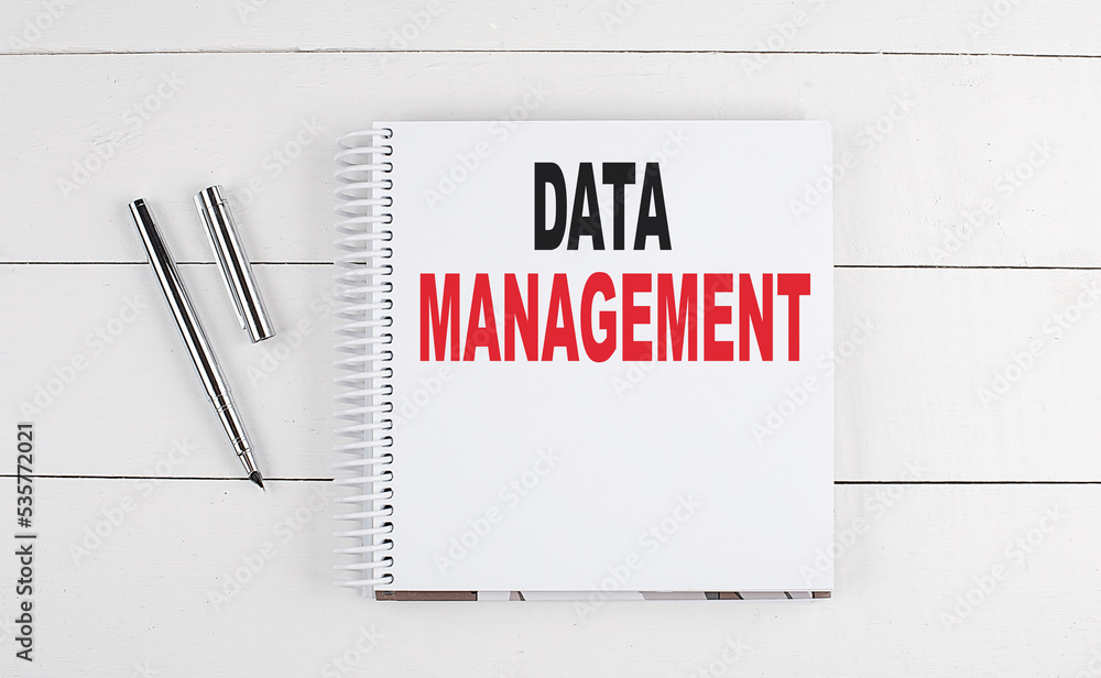 Poster data management text written on notebook on the wooden background