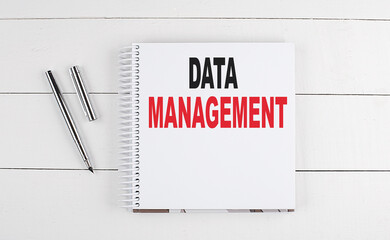 DATA MANAGEMENT text written on notebook on the wooden background