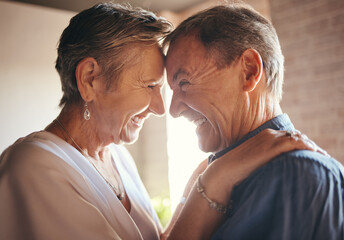 Love, happy and laugh elderly couple hug and bond in their home together, cheerful and sharing a...