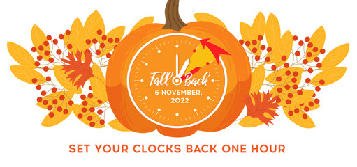 Daylight saving time, 2022 concept. Alarm clock and calendar with the date of November 6 on the pumpkin with autumn leafs decoration