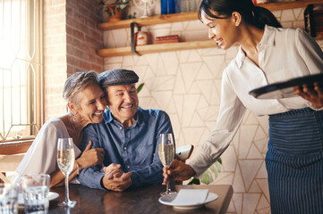 Love, couple elderly and celebrate marriage with date and wine at restaurant, happy, smile or relax together. Loving, senior man and woman with champagne for celebration of retirement or anniversary