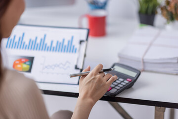 Asian businesswoman Accounting using calculating income-expenditure and analyzing real estate investment data report Financial and tax systems concept.