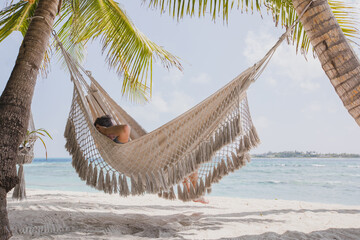 man relaxing in hammock on paradise tropical beach, holidays or vacation travel concept