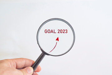 Paper airplane flying to 2023 hefe in magnifying glass. business creativity new idea discovery innovation technology. new year new goal idea concept.