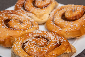 Many tasty cinnabons buns (kanelbullar) with sugar filling, swedish specialty
