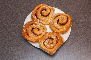 Many tasty cinnabons buns (kanelbullar) with sugar filling, swedish specialty
