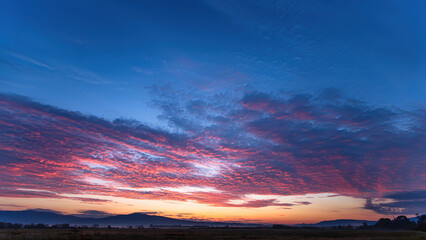 Fototapeta premium Majestic sunset or sunrise landscape with clouds and mountains. olorful sky with clouds