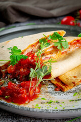 Pita bread with chicken and cheese filling. Pancakes with tomato filling