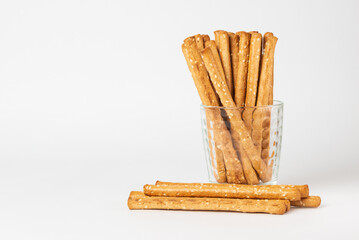 Classic crispy bread sticks grissini in glass. Traditional Italian pastry breadsticks on white background with copy space