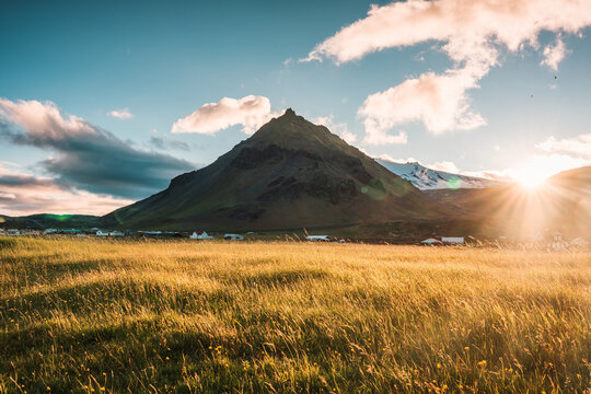 Sunset over Stapafell mountain and glowing meadow in Arnarstapi village on summer at Iceland