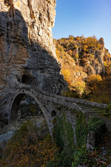 View of the traditional stone Kokkorou Bridge in Epirus, Greece in Autumn.