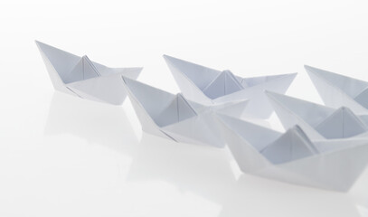 Group of origami boats on white background