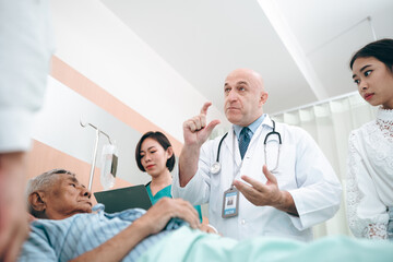 Fototapeta premium professional doctor standing by explain the treatment information via male elderly patient lying in bed in private hospital sickroom. The treatment program is suitable for people to socialize elderly