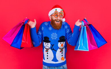 new year shopping sale. surprised man with shopping bag after new year sale. santa man