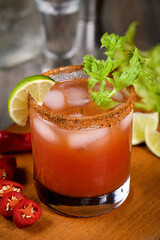 Michelada the Mexican Bloody Mary. Made with tequila, spicy sauce, served over ice in a glass of celery with a peppery rim, garnished with a stalk of celery and a wedge of lime. Drinks and cocktails w