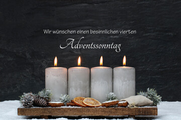 Dekoration zum vierten Advent. Vier brennende Kerzen mit Zimtsternen, Orangenscheiben und...