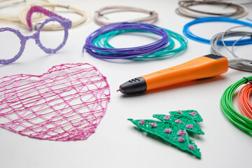 3d Pen. Printing with Colored Plastic Wire Filament. Child making a Christmas Three, Heart shape drawing with 3D pen. Artwork, Robotics. STEAM, STEM education. Modern Technologies. Study at home