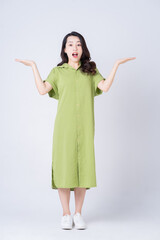 Full length image of young Asian woman wearing green dress on background