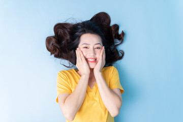 Image of young Asian woman lying on background