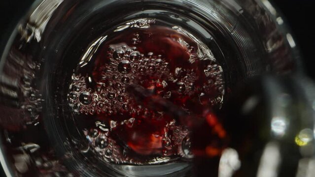 The camera slides up as I pour wine into a glass through grapes. Dolly slider extreme close-up.