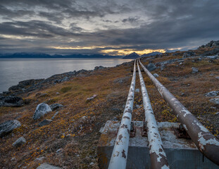 Above ground utilities on the tundra next to the Arctic Ocean at Pond Inlet (Mittimatalik),...