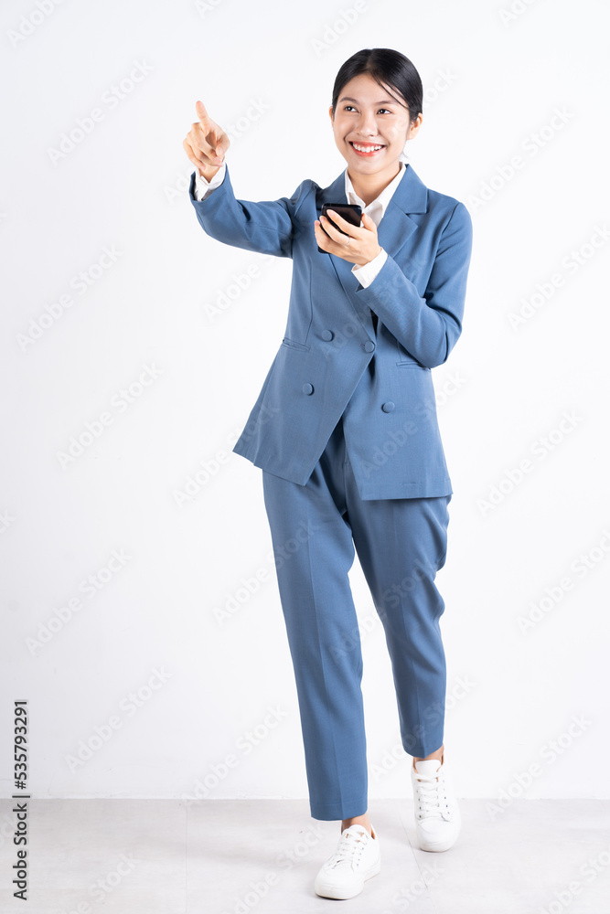 Canvas Prints Full length image of young Asian business woman using smartphone