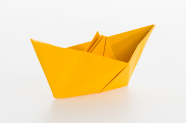 Naklejka premium Yellow origami boat on white background