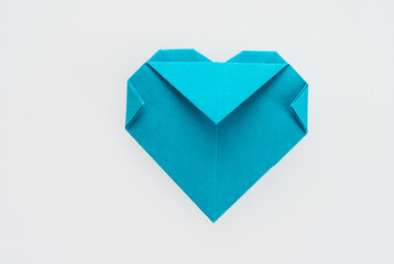 Blue origami heart on white background