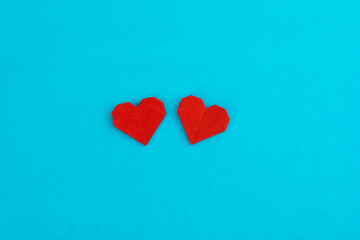 Red origami hearts on blue background