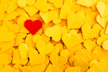 Red origami heart on yellow origami hearts