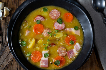 Hearty rustic pea soup with bacon and sausage
