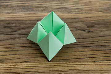 Origami paper fortune on wooden table