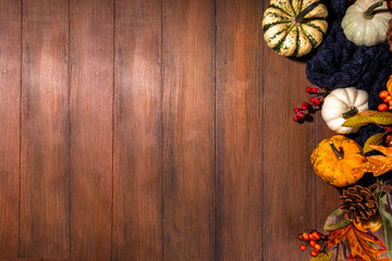 Festive autumn decorated background. Old wooden plank table with fall decoration, pumpkins, berries and leaves. Thanksgiving day, Halloween, autumn holiday greeting card copy space for text
