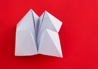 Origami paper fortune on red background