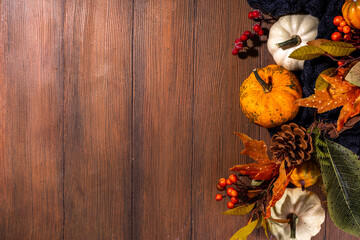 Festive autumn decorated background. Old wooden plank table with fall decoration, pumpkins, berries and leaves. Thanksgiving day, Halloween, autumn holiday greeting card copy space for text