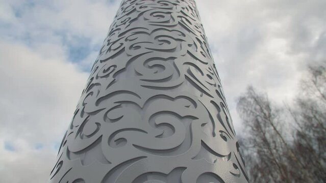 Pillar with traditional Tatar floral pattern under sky with white clouds in city park closeup. National culture representation