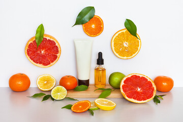 Beautiful bright still life with cosmetic products with citrus extract on wooden podium and sliced...