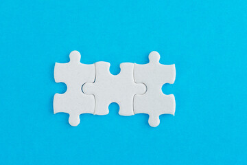 Fototapeta premium Three puzzle pieces on blue background