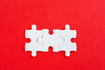 Three puzzle pieces on red background
