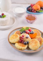 Cheesecakes with fresh berries on a table with a white tablecloth