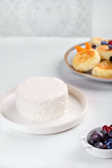 Cottage cheese, cream, milk in a light bowl on a white table