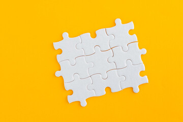White puzzle pieces on yellow background
