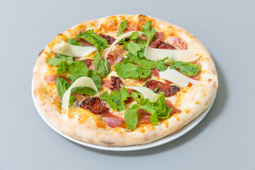 Pizza with arugula prosciutto and dry tomato