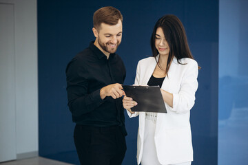 Colleagues walking together at the office and reading tablet