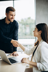 Two business people shaking hands at the office