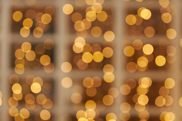 blurred window frame decorated with glowing yellow light garland. Christmas, New Year background and backdrop