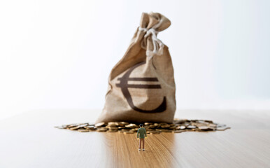 Man figurine and money bag on the table