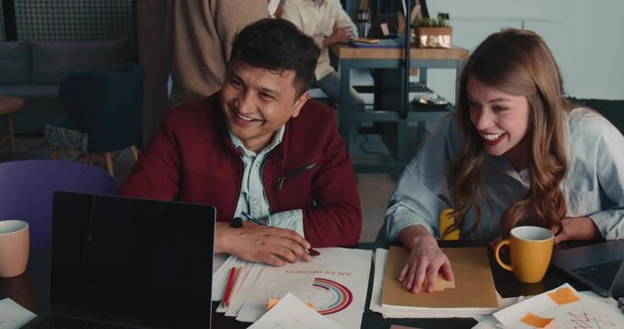Two happy multiethnic HR managers listen, smile and nod to customer woman at office meeting interview slow motion.